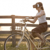 VR機を付けて自転車に乗る女性の画像